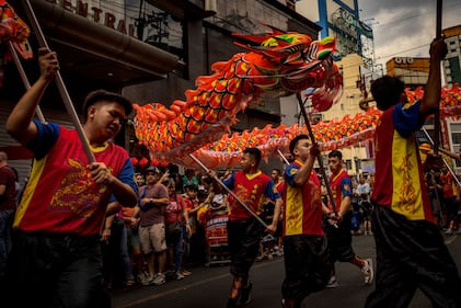 MANILA, PHILIPPINES - FEBRUARY 10: Filipinos watch dragon dancers perform during Lunar New Year celebrations at Binondo district, considered the world's oldest Chinatown, on February 10, 2024 in Manila, Philippines. Lunar New Year, also known as Chinese New Year, is celebrated around the world, and the year of the Wood Dragon in 2024 is associated with growth, progress, and abundance, as wood represents vitality and creativity, while the dragon symbolizes success, intelligence, and honor.  (Photo by Ezra Acayan/Getty Images)