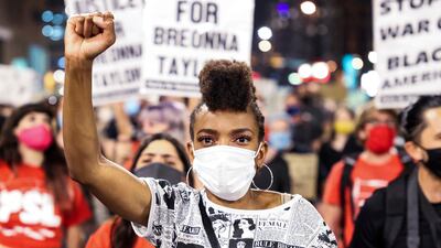 Sheree Barbour holds her fist in the air as people protest the grand jury decision in the Breonna Taylor case on September 23, 2020, in Denver, United States.